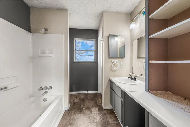 a spacious bathroom with a bathtub sink and mirror