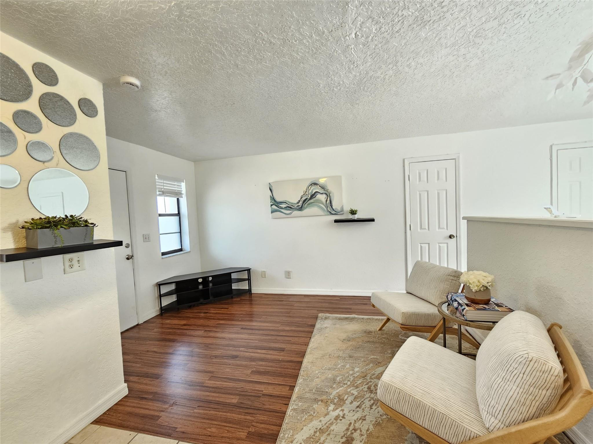 1021 Southeast Monterey Road, Unit 139 Stuart, FL 34994 - Photo 2 of 9 a living room with furniture and a wooden floor