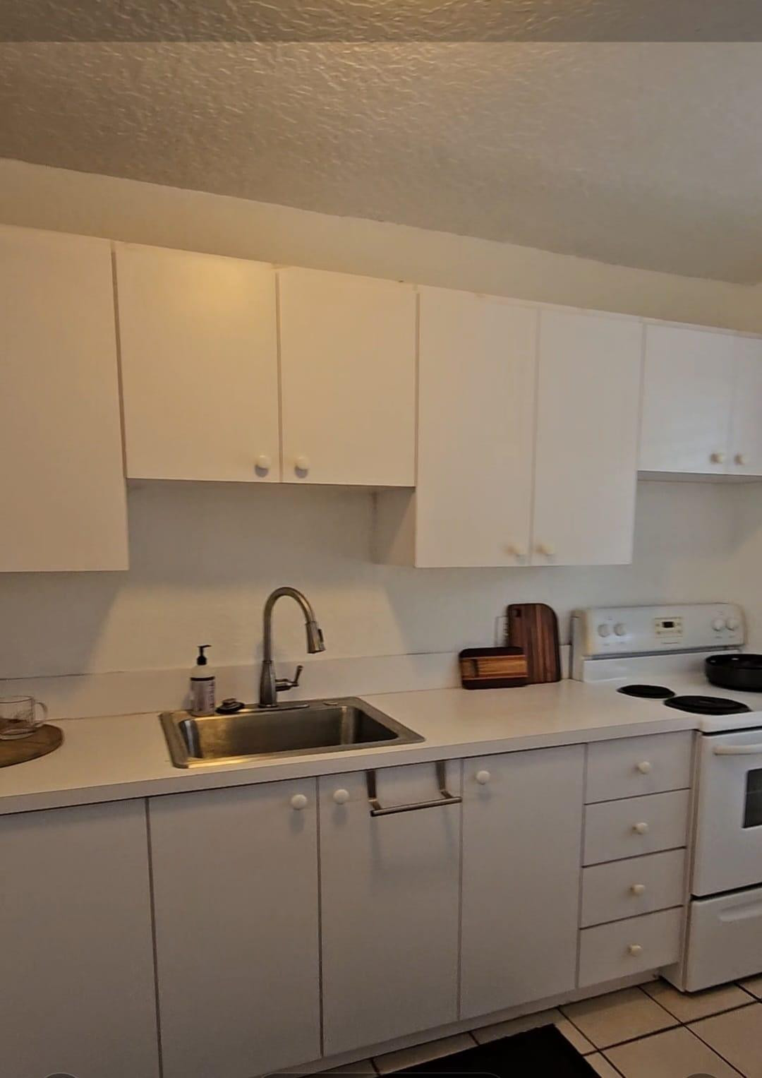 1021 Southeast Monterey Road, Unit 139 Stuart, FL 34994 - Photo 5 of 9 a kitchen with appliances a sink and cabinets