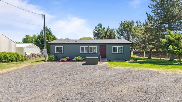 a front view of a house with a yard and trees