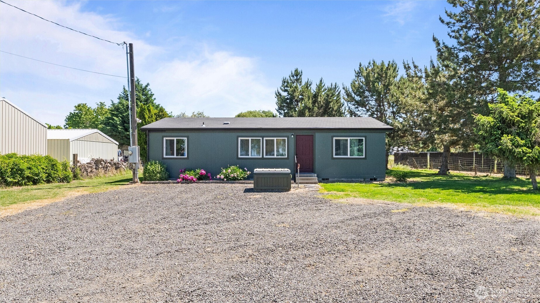 a front view of a house with a yard and trees