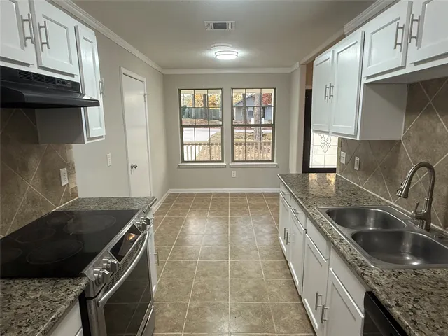 a kitchen with a sink stove and cabinets