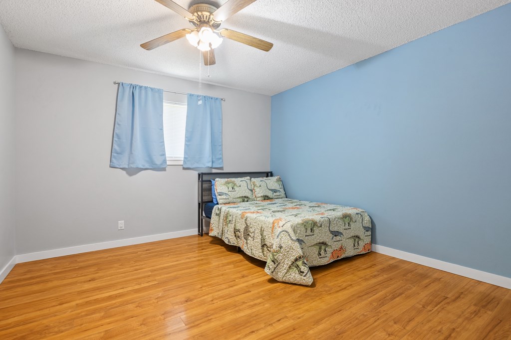 64 Quail Run Harper, TX 78631 - Photo 13 of 25 a bedroom with a bed and a chandelier