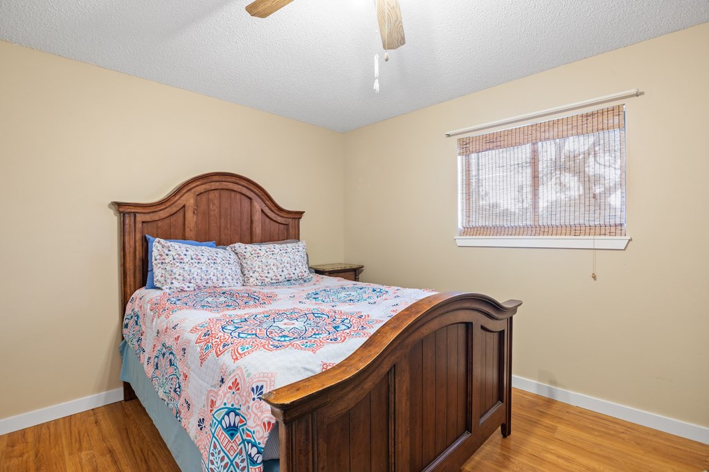 64 Quail Run Harper, TX 78631 - Photo 14 of 25 a bedroom with a bed and wooden floor