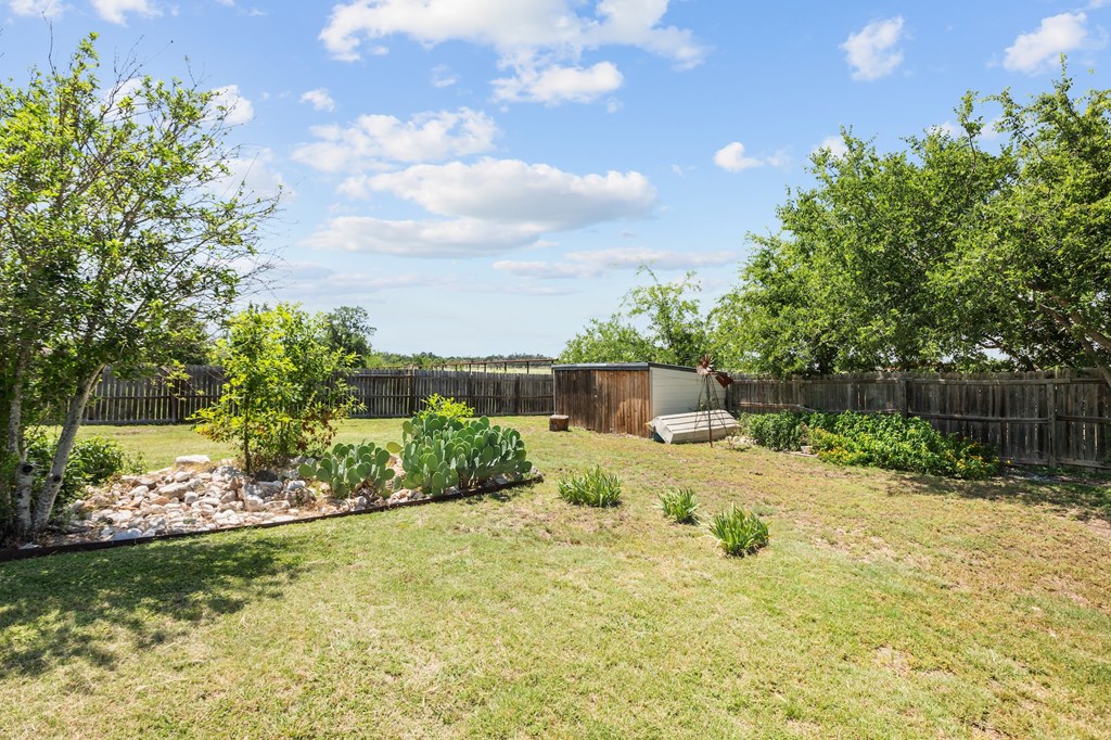 64 Quail Run Harper, TX 78631 - Photo 19 of 25 a backyard of a house with lots of green space and garden