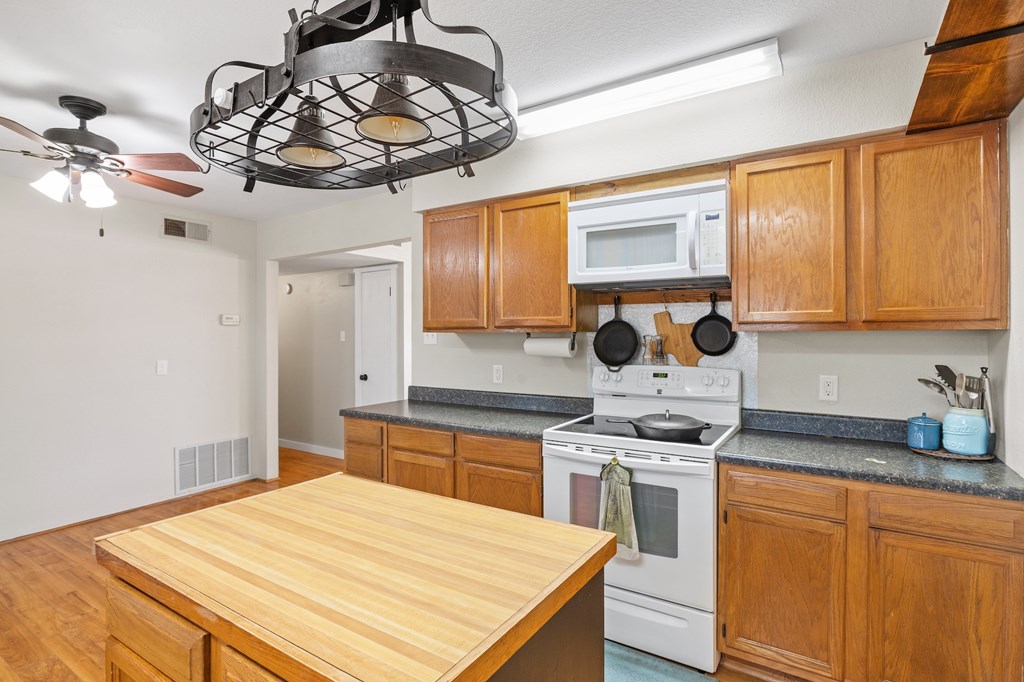 64 Quail Run Harper, TX 78631 - Photo 10 of 25 a kitchen with stainless steel appliances a stove a sink dishwasher cabinets and dining table with wooden floor