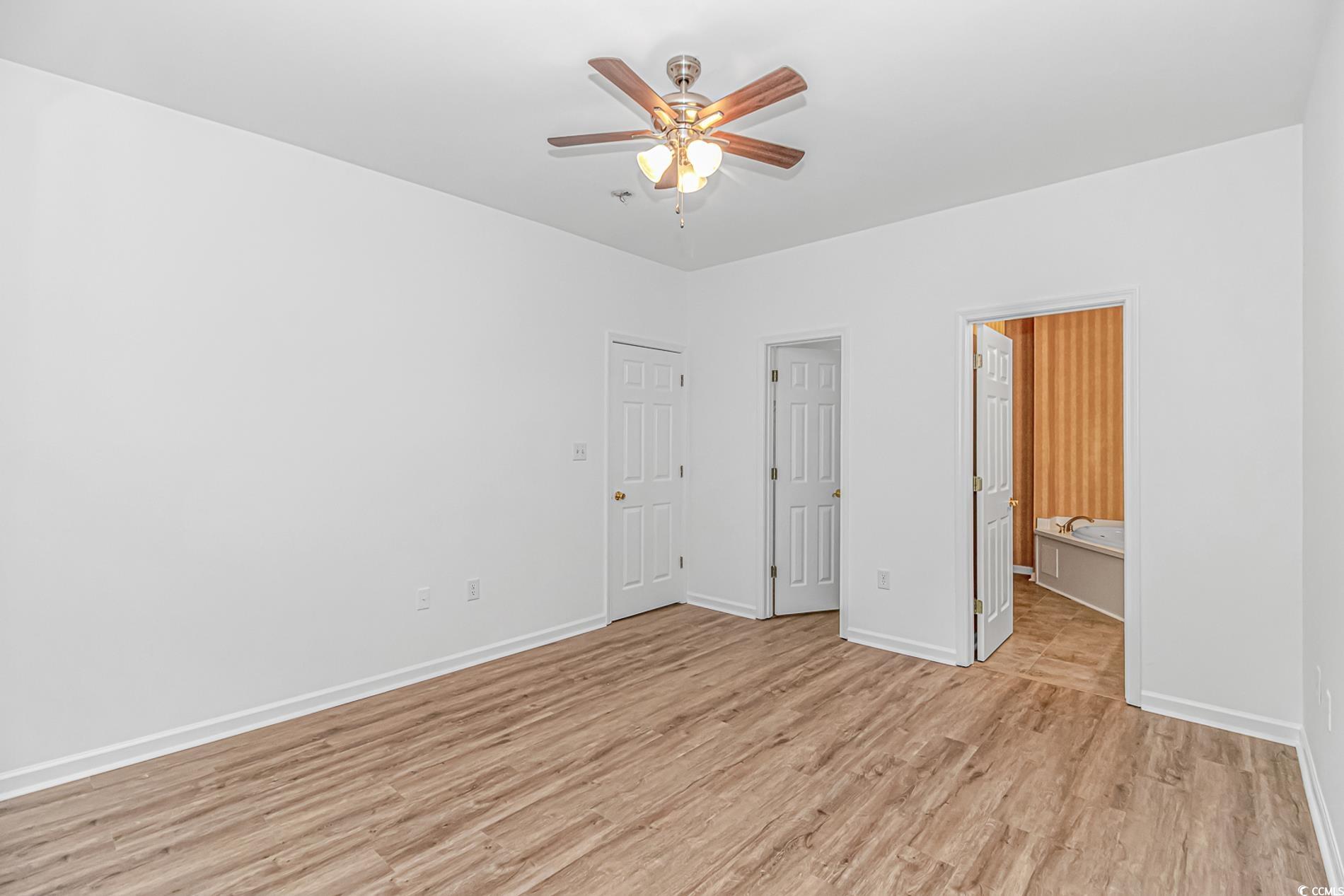 4814 Innisbrook Court, Unit 407 Myrtle Beach, SC 29579 - Photo 15 of 31 Unfurnished bedroom with light wood-style flooring, a ceiling fan, and ensuite bathroom