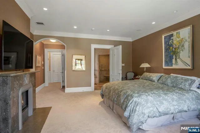 a spacious bedroom with a large bed and a fireplace