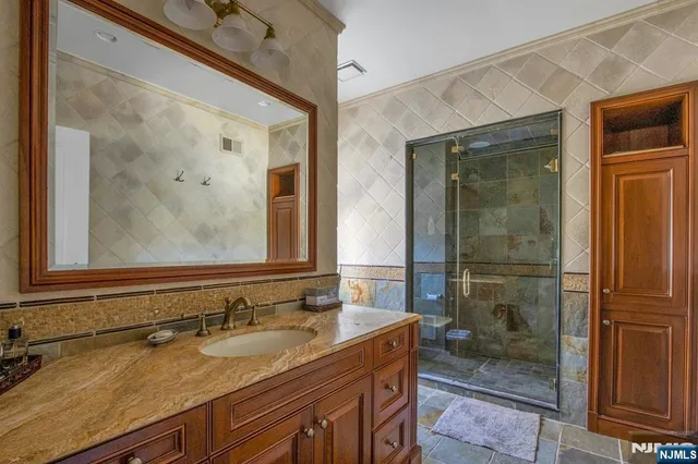 a bathroom with a granite countertop sink mirror and shower