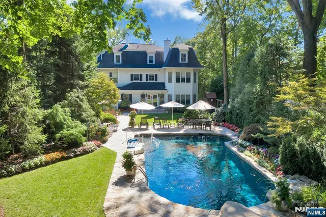 a front view of a house with swimming pool having outdoor seating