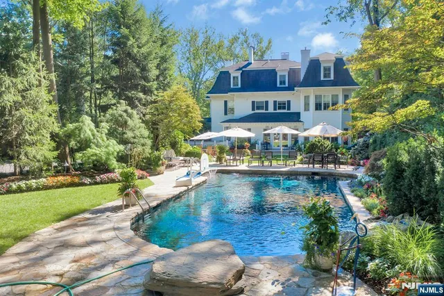 a view of a house with a yard and a large tree