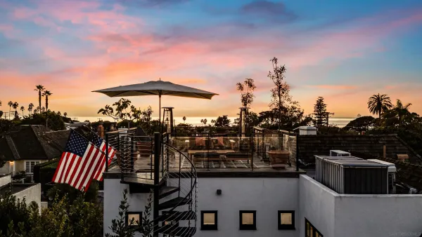 a view of a patio with table and chairs under an umbrella