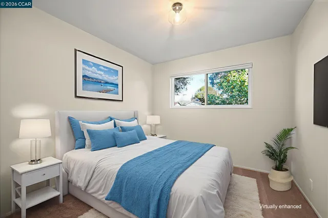 a bedroom with bed and a painting on the wall