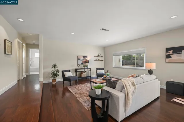 a living room with furniture and a wooden floor