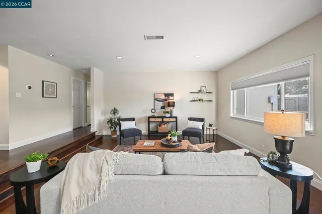 a living room with furniture and a mirror