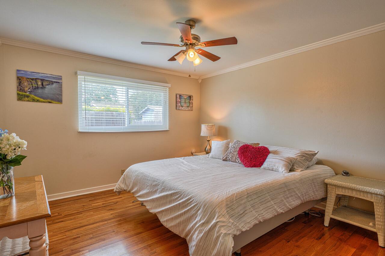 918 Junipero Way Salinas, CA 93901 - Photo 23 of 33 a bedroom with a bed and a table with wooden floor