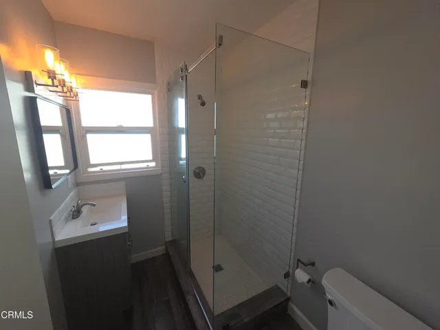 a bathroom with a shower a sink and a toilet