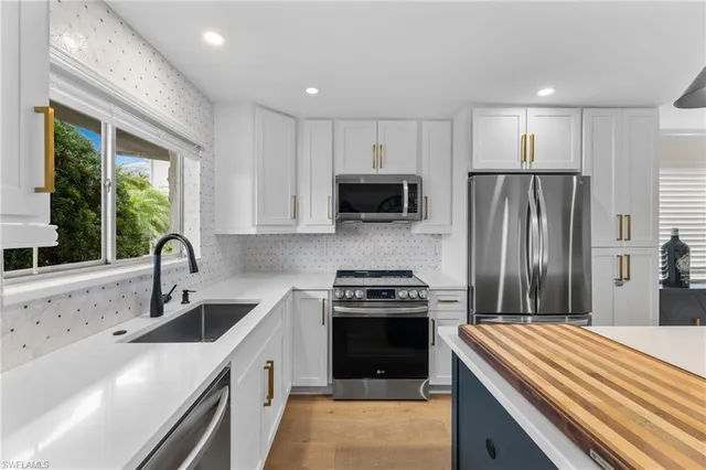 a kitchen with stainless steel appliances granite countertop a sink stove and refrigerator