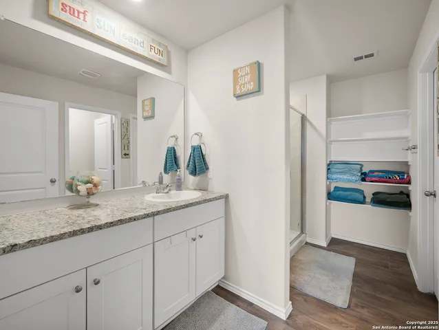 a en suite bathroom with a granite countertop sink and a mirror