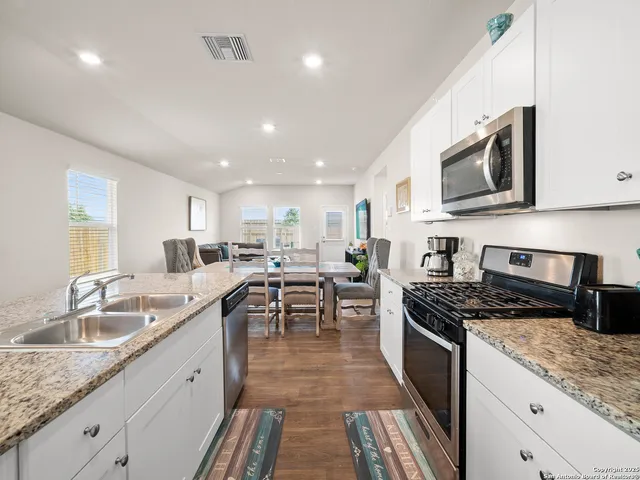 a kitchen with stainless steel appliances granite countertop a sink stove and microwave