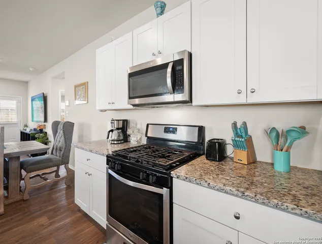 a kitchen with white cabinets and appliances