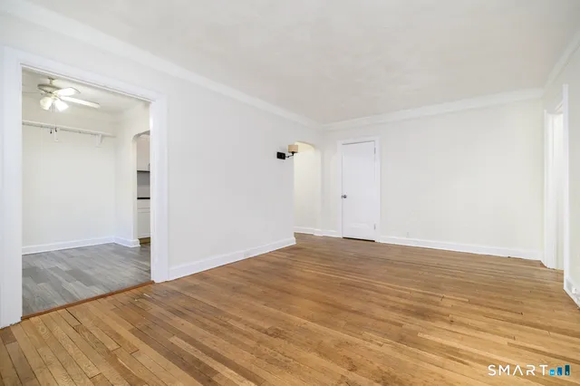 a view of empty room with wooden floor