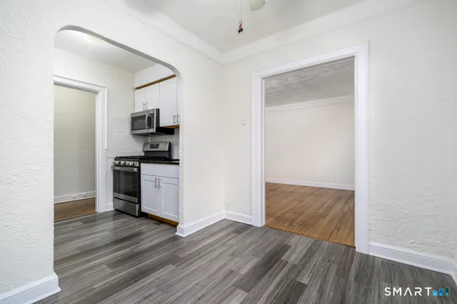 a view of kitchen with wooden floor and electronic appliances