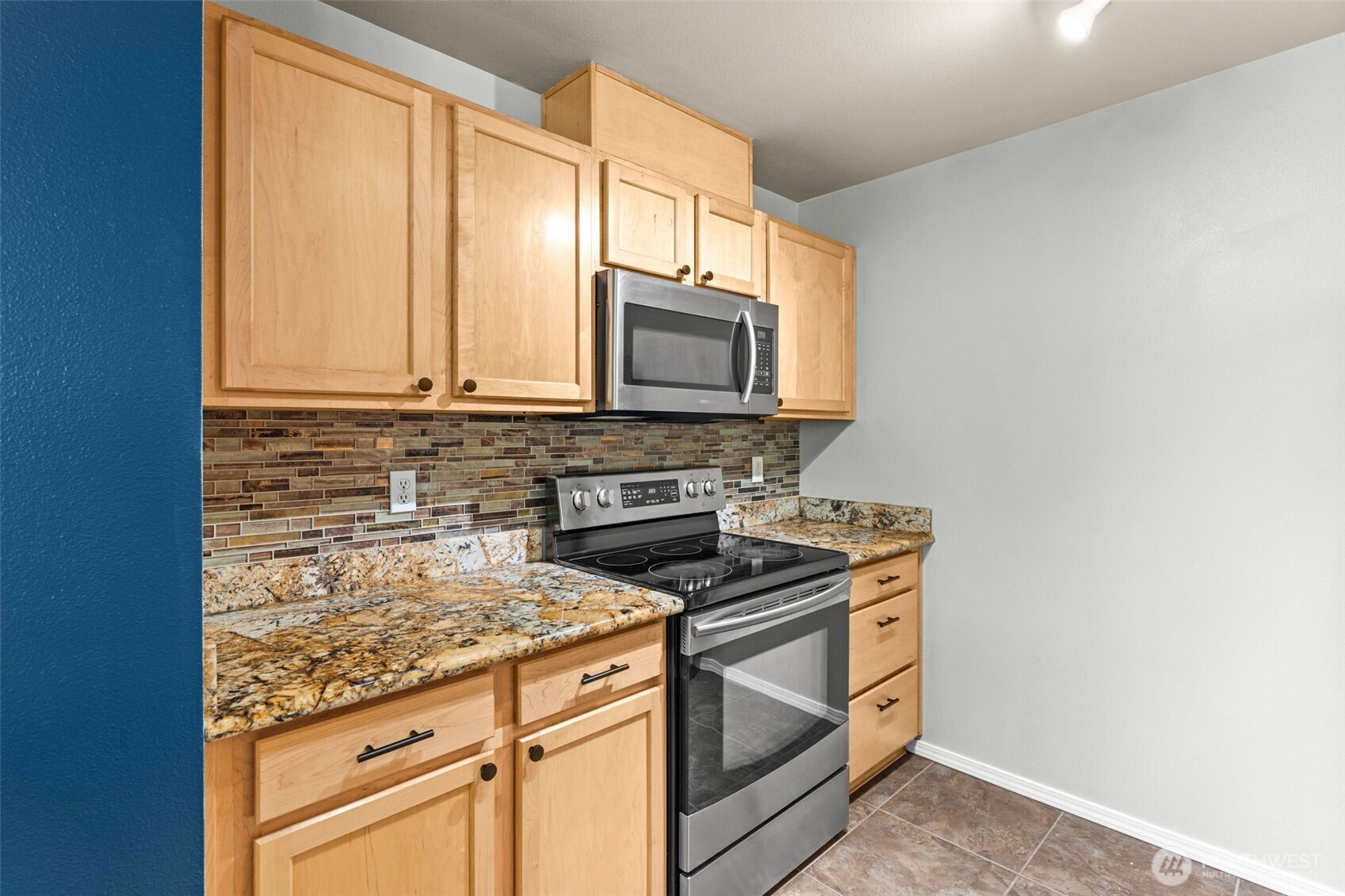 6137 Hazel Loop Southeast, Unit A8 Auburn, WA 98092 - Photo 15 of 40 a kitchen with stainless steel appliances granite countertop a stove microwave and sink