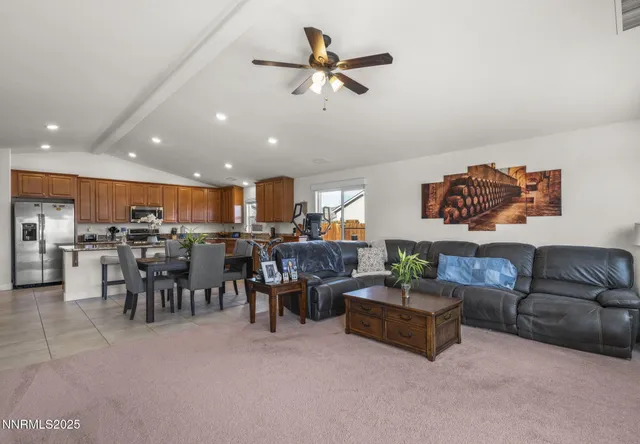 a living room with furniture kitchen view and a chandelier