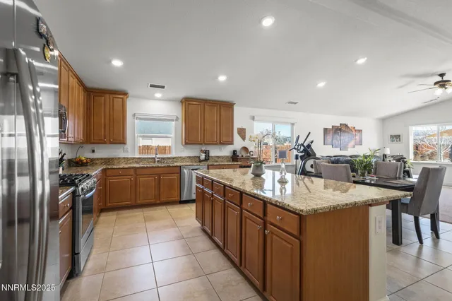 a kitchen with stainless steel appliances granite countertop a sink counter space cabinets and a refrigerator