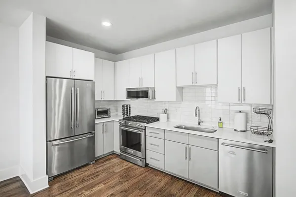 a kitchen with a refrigerator stove and white cabinets