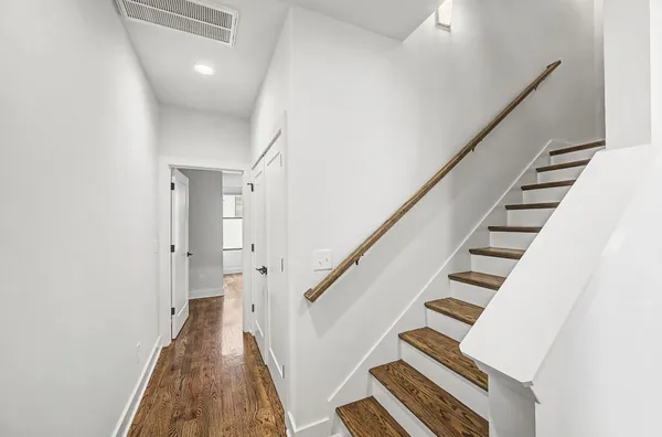 a view of staircase with wooden floor and white walls