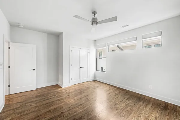 a view of a room with wooden floor and a ceiling fan