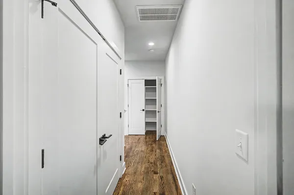 a view of a hallway with wooden floor and staircase