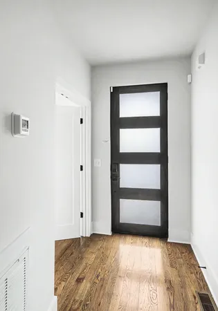 a view of an empty room with wooden floor and closet