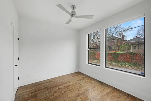 a view of an empty room with a window and a ceiling fan