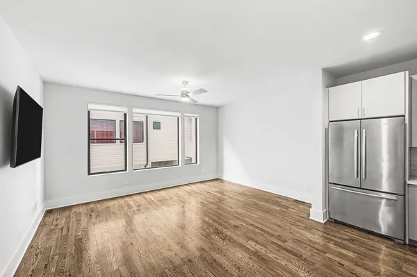 a view of an empty room with a window and wooden floor