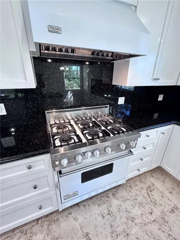 a kitchen with a stove sink and cabinets