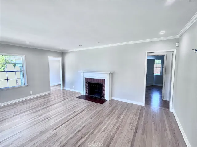 a kitchen with granite countertop a stove a sink a refrigerator cabinets and wooden floor