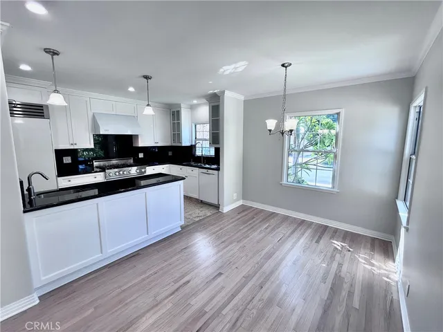 a kitchen with stainless steel appliances granite countertop a stove a sink and a microwave