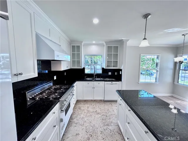 a kitchen with stainless steel appliances granite countertop a sink a stove and a refrigerator