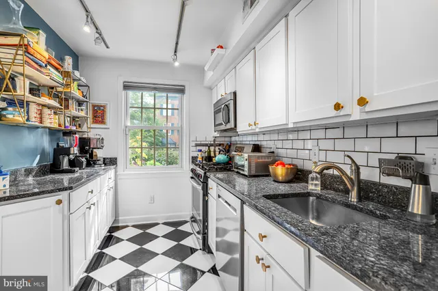 a kitchen with stainless steel appliances granite countertop a sink stove and cabinets