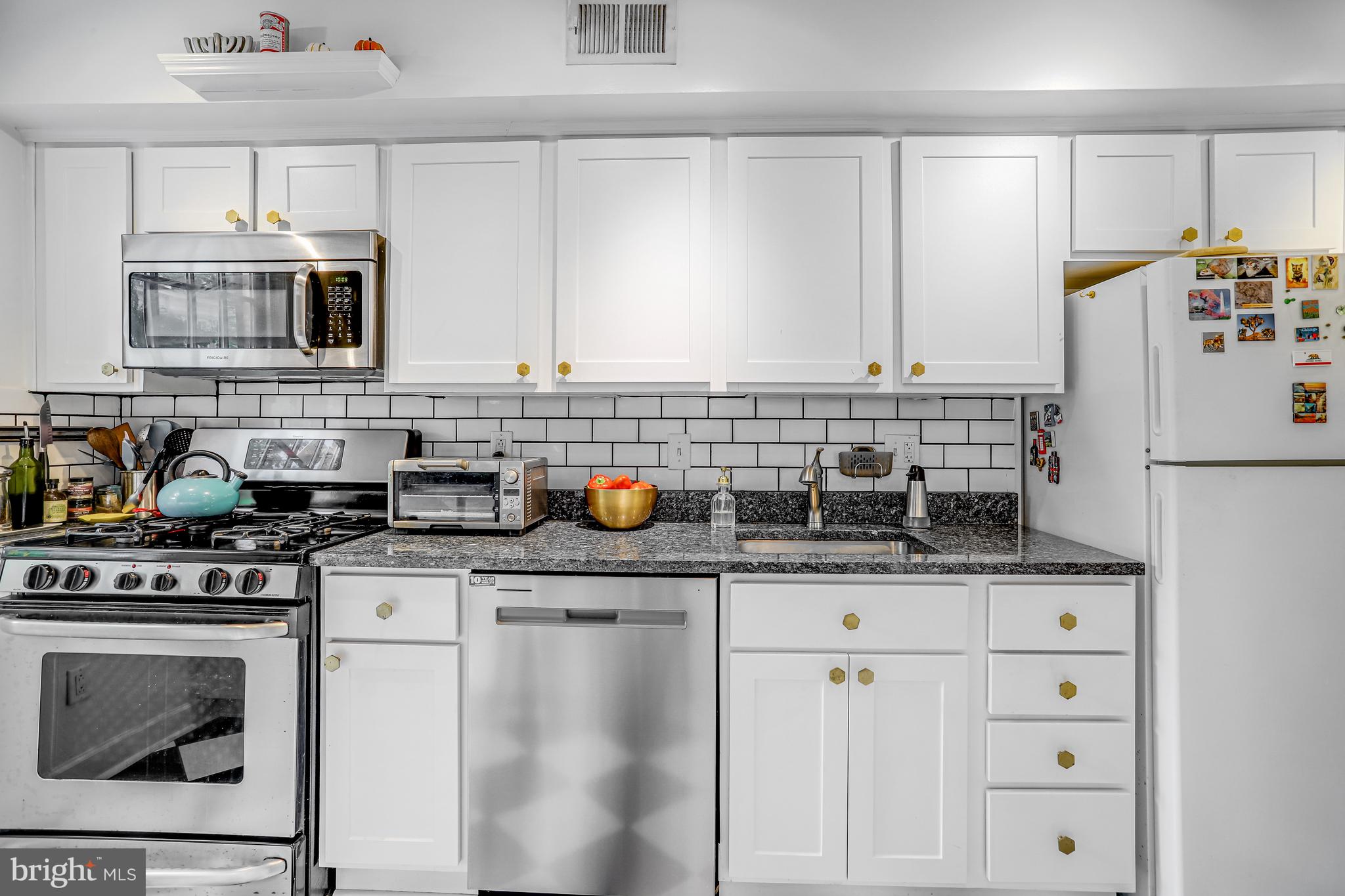 213 9th Street Southeast Washington, DC 20003 - Photo 16 of 74 a kitchen with stainless steel appliances a sink stove and refrigerator