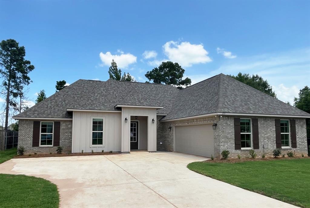 159 Lessie Drive Stonewall, LA 71078 - Photo 1 of 26 a front view of a house with a yard and garage