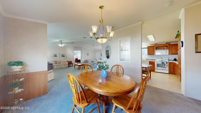 a view of a dining room and livingroom with furniture a chandelier and wooden floor