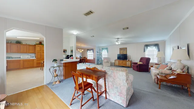 a living room with furniture a dining table and chairs with wooden floor