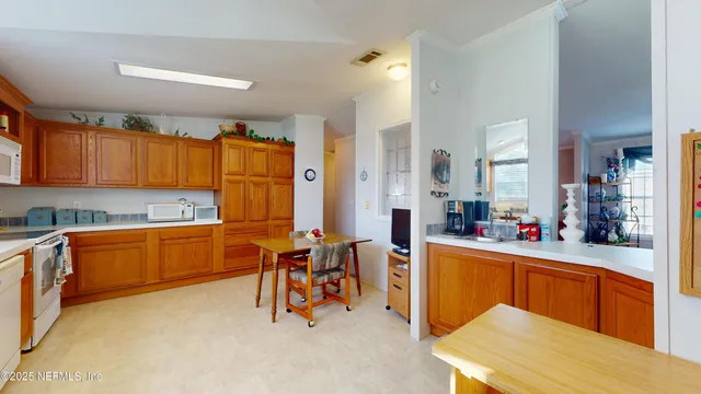 a kitchen with stainless steel appliances kitchen island granite countertop wooden cabinets a dining table and chairs