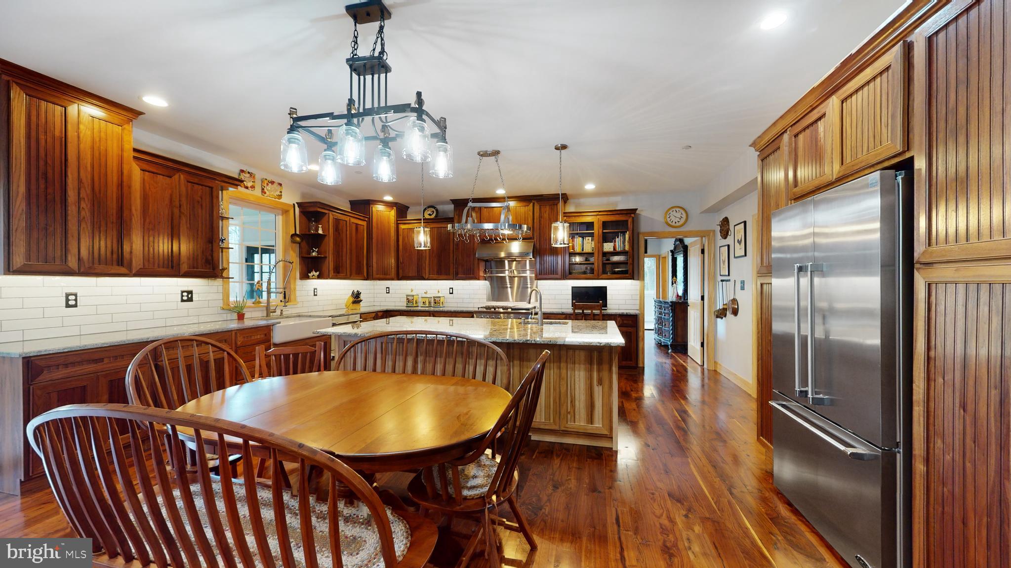 901 Crum Creek Road Springfield, PA 19064 - Photo 13 of 116 a kitchen with stainless steel appliances granite countertop a kitchen island a table and chairs in it
