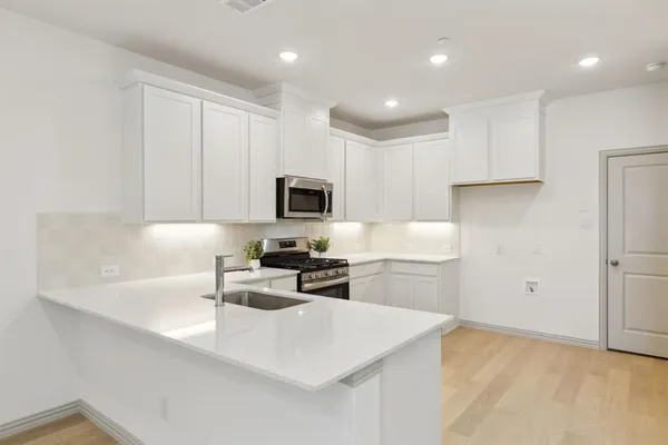 a kitchen with stainless steel appliances granite countertop a stove and a sink