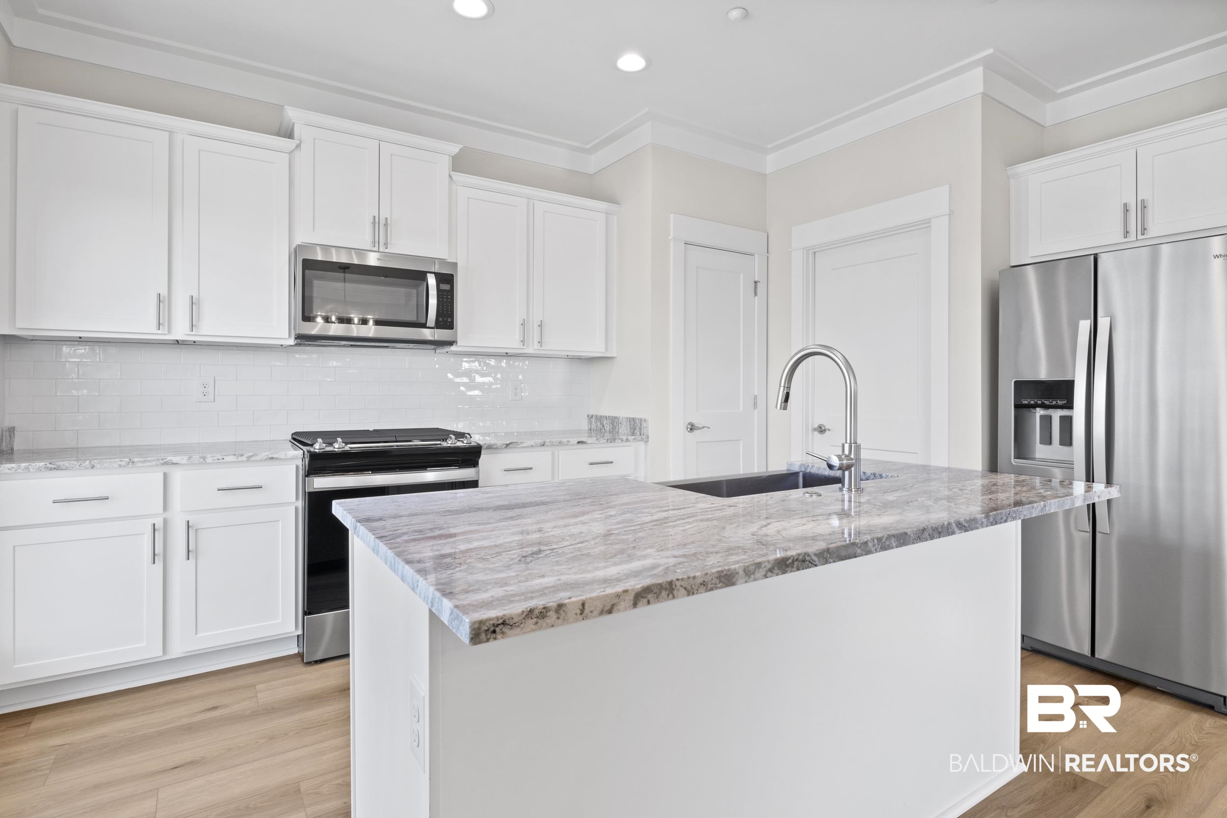2847 Salt Drive Orange Beach, AL 36561 - Photo 12 of 29 Kitchen with appliances with stainless steel finishes, a center island with sink, and white cabinetry